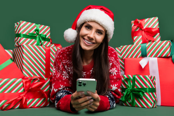 躺着的年轻女孩黑发与男友聊天的照片选择家庭堆礼盒数字销售孤立的绿色背景图片下载