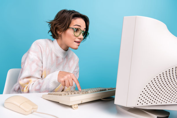 聪明的公司高管咬着嘴唇的照片，手指按在蓝色背景上孤立的旧电脑键盘按钮图片下载