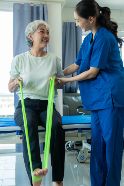 一位年轻的亚洲护士在养老院照顾一位老年妇女。主治医师为老年患者提供物理治疗服务，锻炼身体，促进健康。图片下载