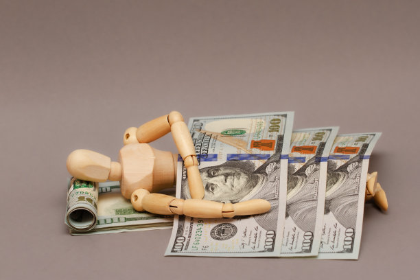 木头人睡在百元大钞做成的毯子上。图片下载