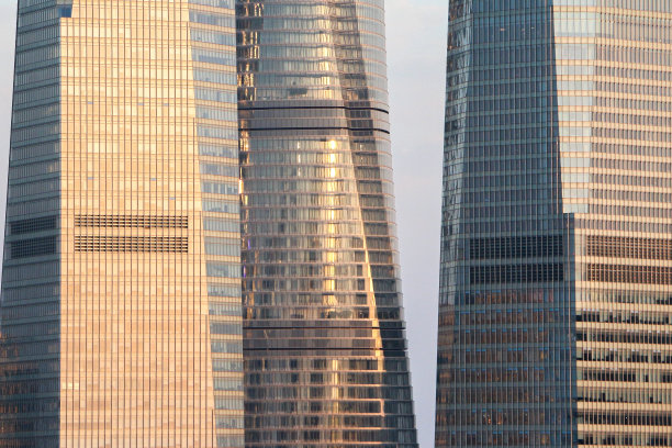 上海现代办公大楼和摩天大楼的外立面，阳光从公司的玻璃塔上反射回来图片下载