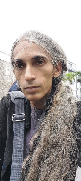 长发男人背着单肩包户外自拍图片下载