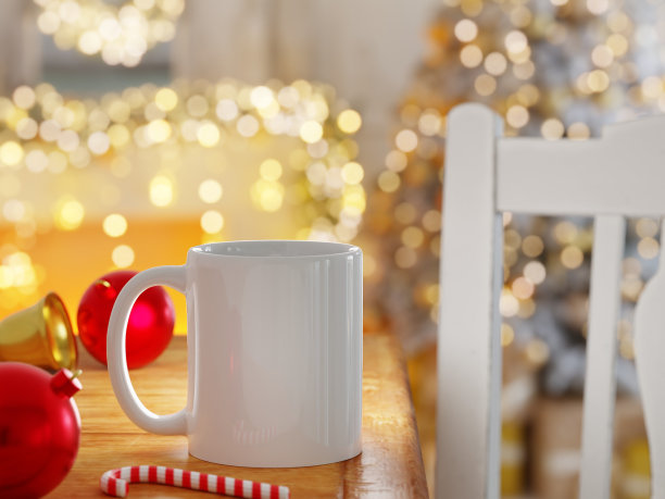 白色的咖啡杯，装饰和明亮的灯光在圣诞场景中散乱图片下载