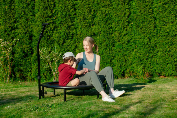 妈妈和儿子在户外蹦床上玩得很开心图片下载