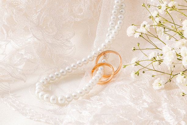 复古的米色薄纱和长长的珍珠珠沿着柔软的褶皱垂下，上面戴着金色的结婚戒指。一个拷贝空间。模型图片下载