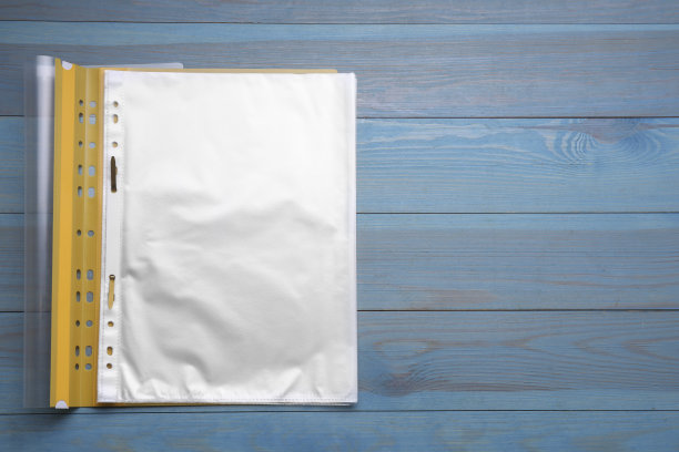 文件夹与穿孔口袋上浅蓝色的木桌，顶视图。文本空间图片下载