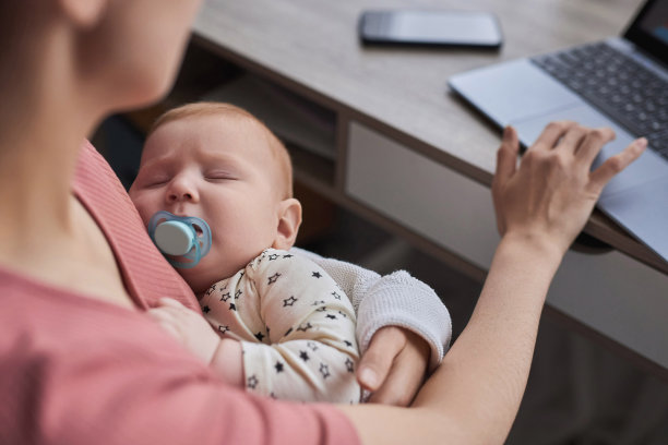 职业妈妈用笔记本电脑抱着孩子图片下载