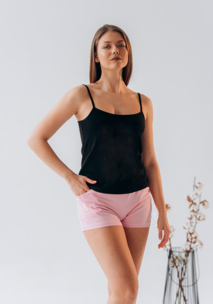 穿着丝绸睡衣的白人美女。白色背景下穿着短裤和背心的女孩图片下载