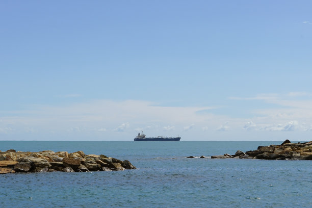 油轮在地平线上平静湛蓝的海面上，天空晴朗，阳光明媚。图片下载