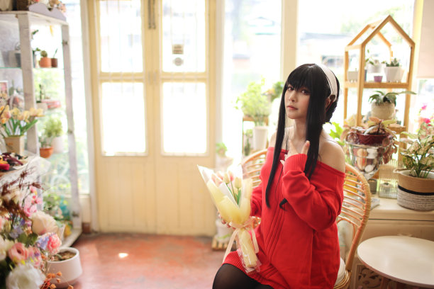 一个漂亮的年轻女子在花店穿着红毛衣Cosplay的肖像图片下载