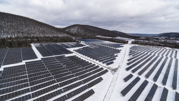 大雪过后一个阳光明媚的冬日，宾夕法尼亚州阿巴拉契亚山脉的大型太阳能农场。图片下载