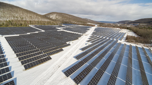 大雪过后一个阳光明媚的冬日，宾夕法尼亚州阿巴拉契亚山脉的大型太阳能农场。图片下载
