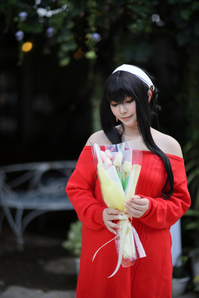 一个漂亮的年轻女子在花店穿着红毛衣Cosplay的肖像图片下载