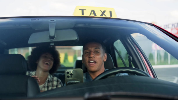 快乐的非裔美国出租车司机和坐在后座上的女士交谈。黄色出租车车顶标志。人、工作、服务理念。图片下载