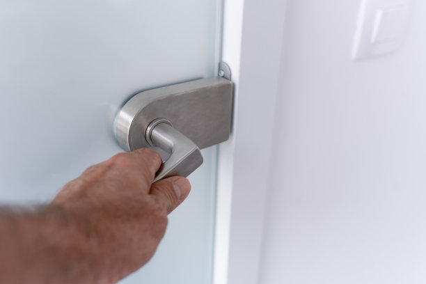 一只手放在玻璃门把手上图片下载