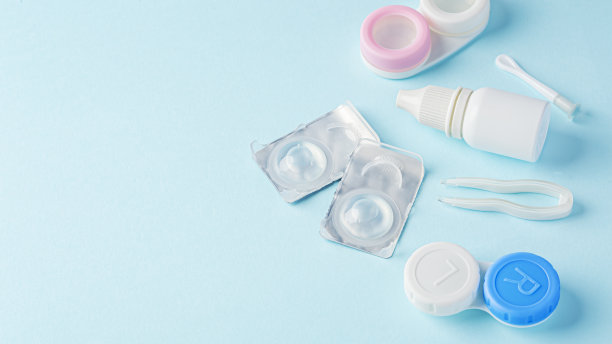 隐形眼镜与容器，眼药水和镊子在蓝色背景图片下载