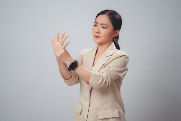 在白色背景上孤独地站立着遭受手部疼痛的亚洲妇女。图片下载