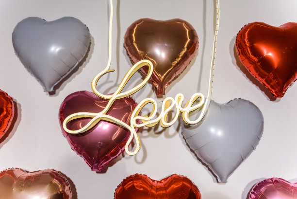 爱心照片区，爱心气球。拱门上有白色、红色、粉色、金色的气球。情人节情侣照墙。惊喜求婚的装饰。餐厅浪漫约会图片下载