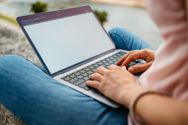 在码头边摆弄笔记本电脑的年轻女子图片下载