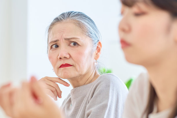 一个年长的女人用一种严肃的表情看着一个年轻的女人图片下载