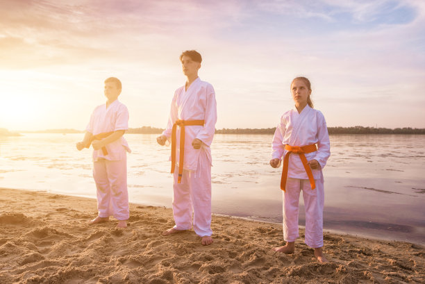 孩子们在河边的沙滩上进行空手道训练图片下载