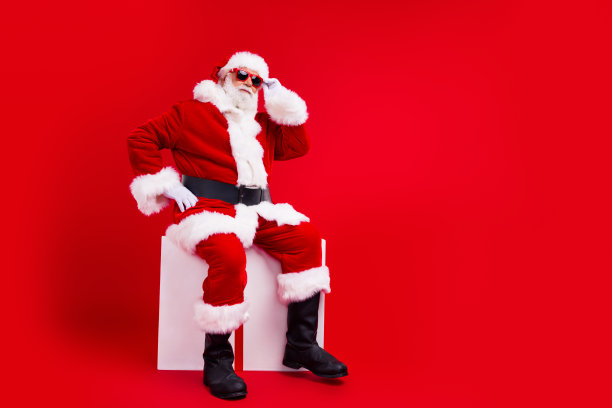 欢乐的退休老人圣诞老人坐在立方体圣诞活动提供空白空间孤立的红色背景的全长照片图片下载