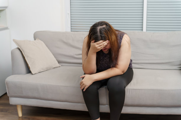 悲伤超重的女人在沙发上思考问题，沮丧的女孩因为糟糕的关系而感到孤独和悲伤，抑郁的女人精神健康失调图片下载