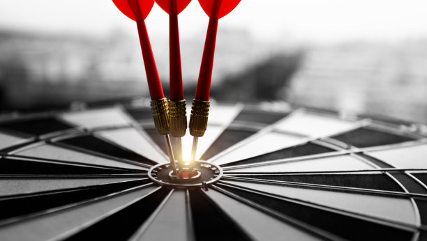 飞镖板上有三个飞镖在红牛的靶心图片下载