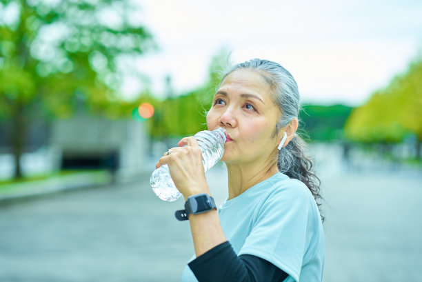 老妇人用塑料瓶喝水图片下载