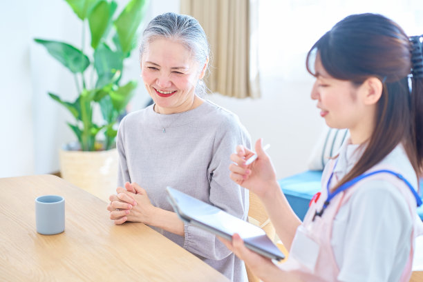 穿围裙的年轻女子和年长女子在家里聊天图片下载