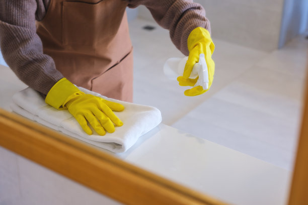 一名妇女戴着防护手套擦拭和清洁浴室的特写照片图片下载