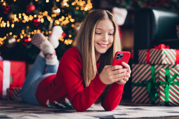 可爱的少女躺在地毯上的照片肖像，享受在家里度过新年假期，没有朋友，只是在网上聊天图片下载