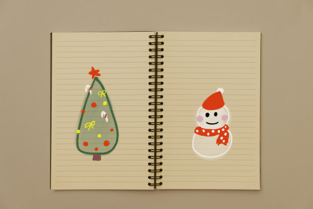 用手在笔记本上画一棵圣诞树和一个雪人。庆祝圣诞节。孩子，回忆和慈善。图片下载