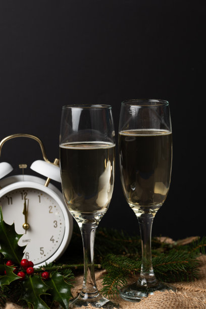 庆祝新年。黑色背景上的香槟。新年背景，两杯香槟准备在黑色背景上带来新年。自由文本空间。图片下载