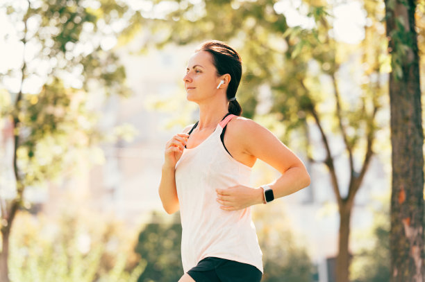 上午，女运动员在城市跑步的侧面照片图片下载