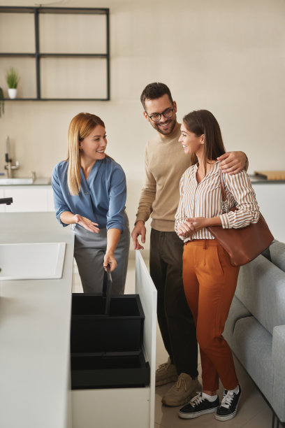 女店员帮助年轻夫妇选择新的垃圾桶图片下载