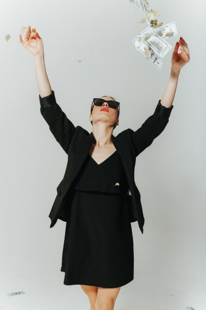 女冠军穿着黑色西装，戴着墨镜，美元和散落的彩纸让她很开心图片下载