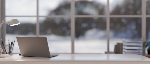 一张办公桌，配有笔记本电脑，一盏台灯，一个铅笔架和一个现代办公室的复印空间图片下载