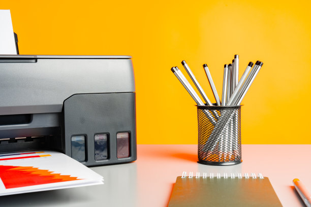 桌子上的激光打印机，黄色背景。图片下载