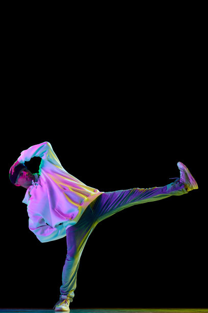 hip-hop男舞者的全身肖像，在混合霓虹灯的黑色背景下，穿着时髦的衣服跳舞的运动员。图片下载