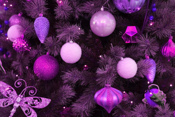 圣诞饰品背景。紫色，紫色装饰玻璃小装饰品。圣诞树上有地球仪、泡泡。闪闪发光的球，圣诞树枝。装饰物品。冬季节日装饰，闪烁的灯光图片下载