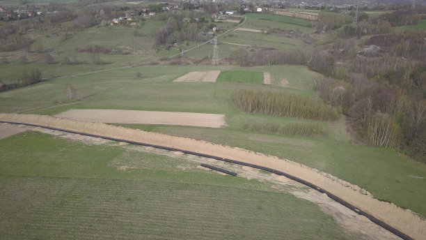 青山间铺设天然气管道。大型高压钢管在开挖的沟槽中浸没。土地在战略产业中起作用。能源和自然资源图片下载