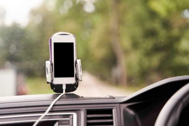 车内支架上的白色智能手机用于导航。图片下载
