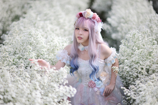 亚洲年轻女子的肖像与洛丽塔时尚服装在白色的花园背景图片下载