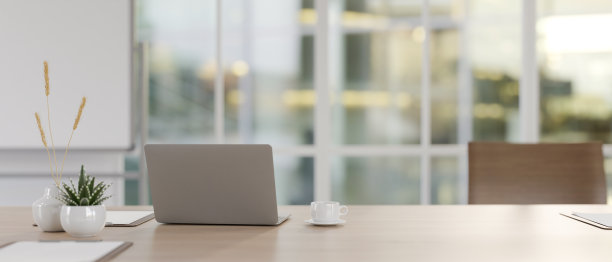 现代会议室里，木制会议桌上的笔记本电脑和配件。图片下载