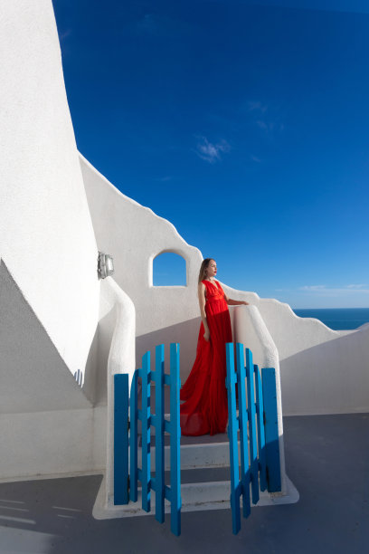 魅力的照片。女孩在大海的背景下挥舞着一件飘逸的红色连衣裙图片下载