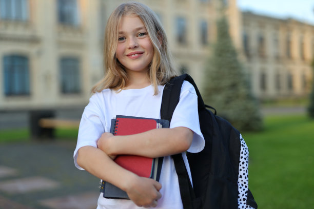 背着书包的可爱女学生在阳光明媚的日子里拥抱学习的乐趣图片下载