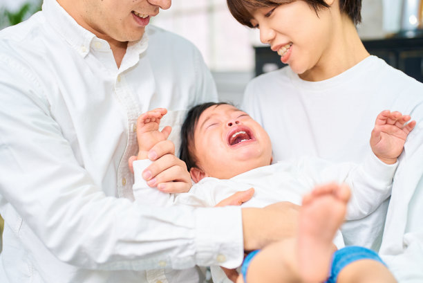 哭闹的婴儿和抱在一起的父母图片下载