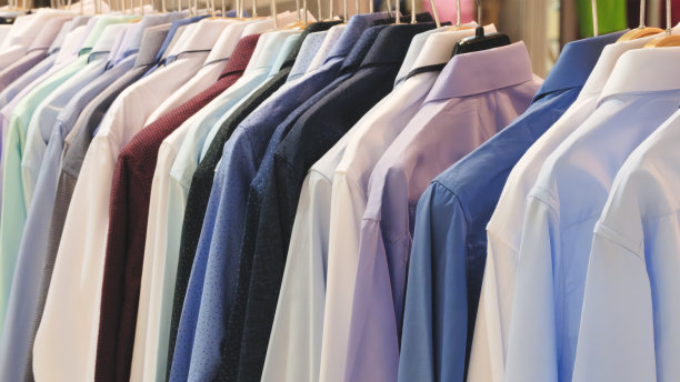 男士衬衫悬挂的特写照片。衣服挂在架子上。衣架与衬衫。男士职业装图片下载