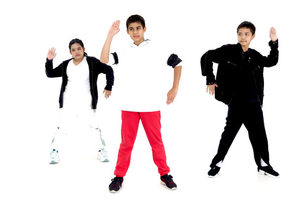 快乐的学生儿童小组在室内工作室教室里学习现代舞，孩子们，男孩和女孩，在白色的背景上跳舞。三个小舞者一起练习霹雳舞。图片下载